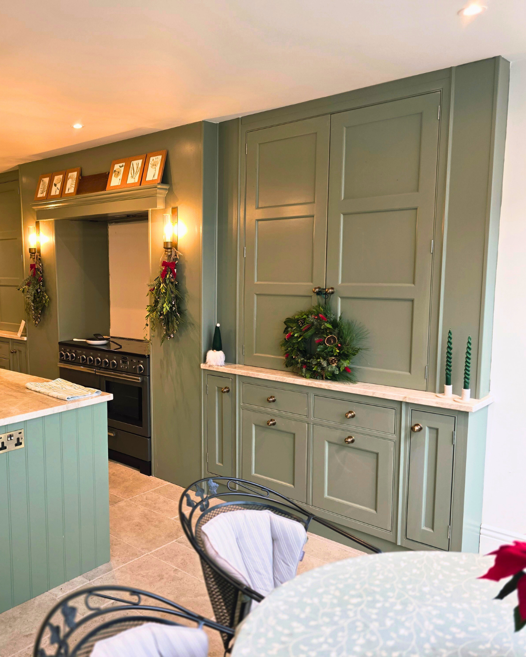 Bespoke sage green pantry cabinetry beside the range cooker
