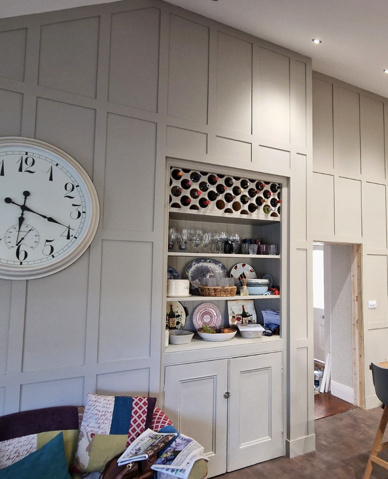 Kitchen and family room with bespoke full-height panelling and integrated wine rack in Guernsey
