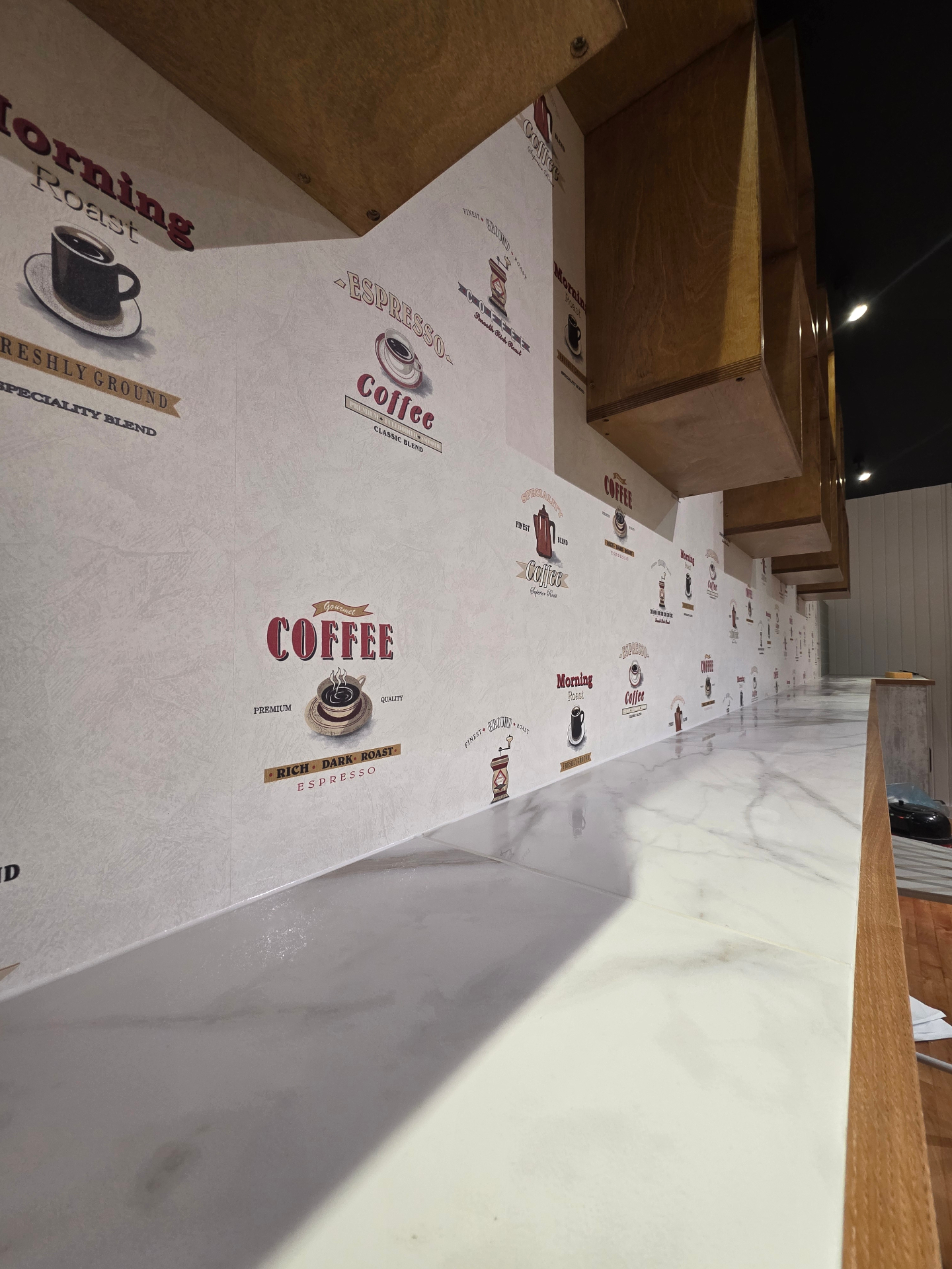 Vintage coffee-print feature wallpaper detail behind the bar seating run