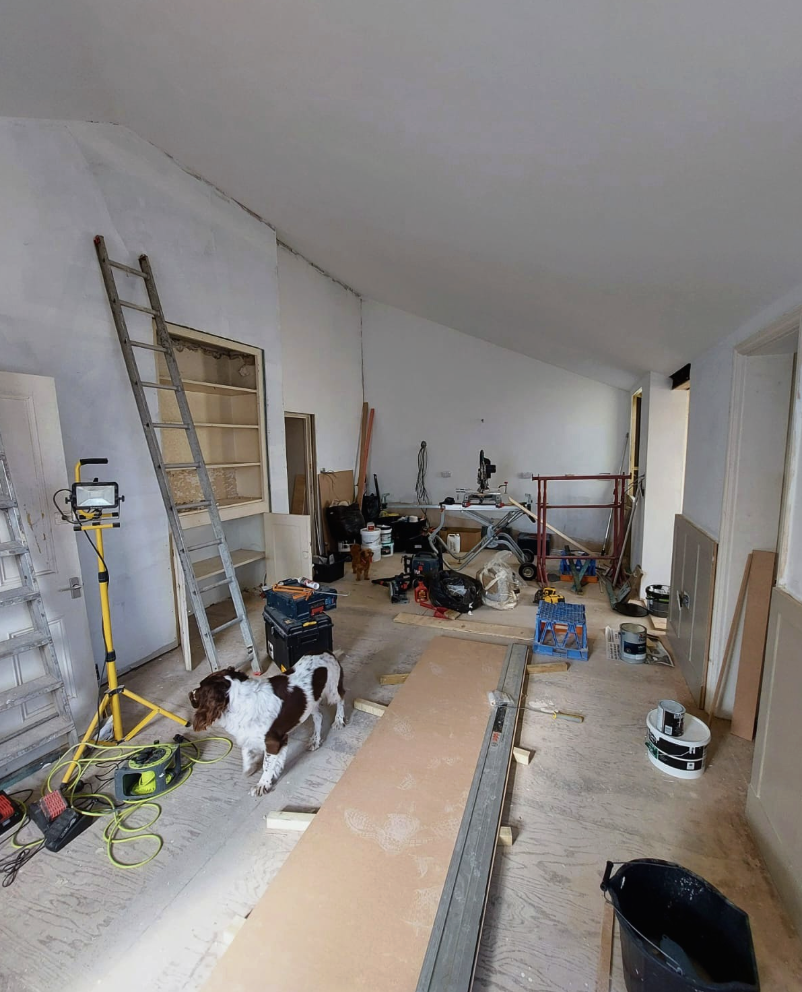 Kitchen and family room stripped back during works with tools and a dog on site