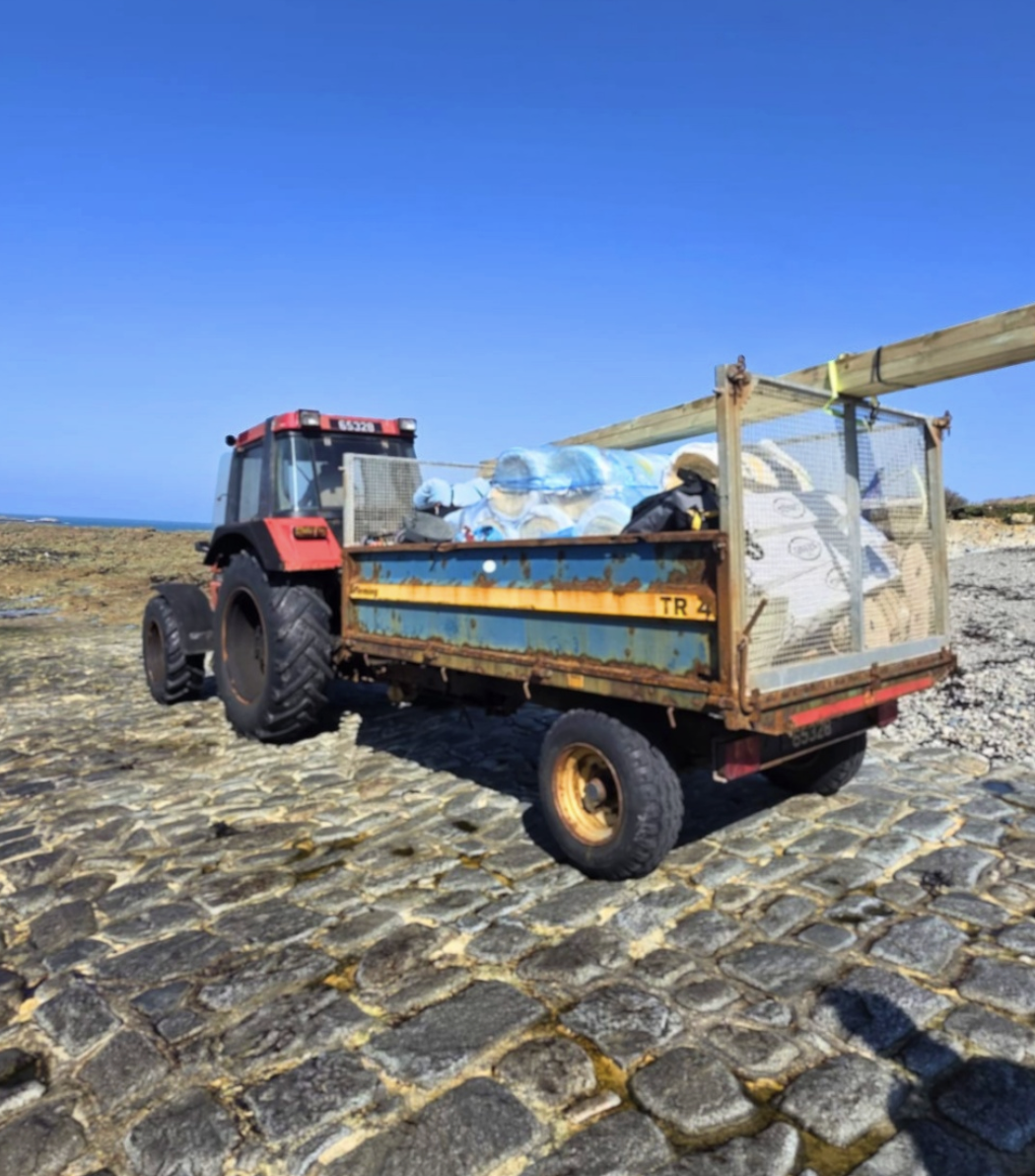 Tractor and trailer transporting materials across the stone causeway