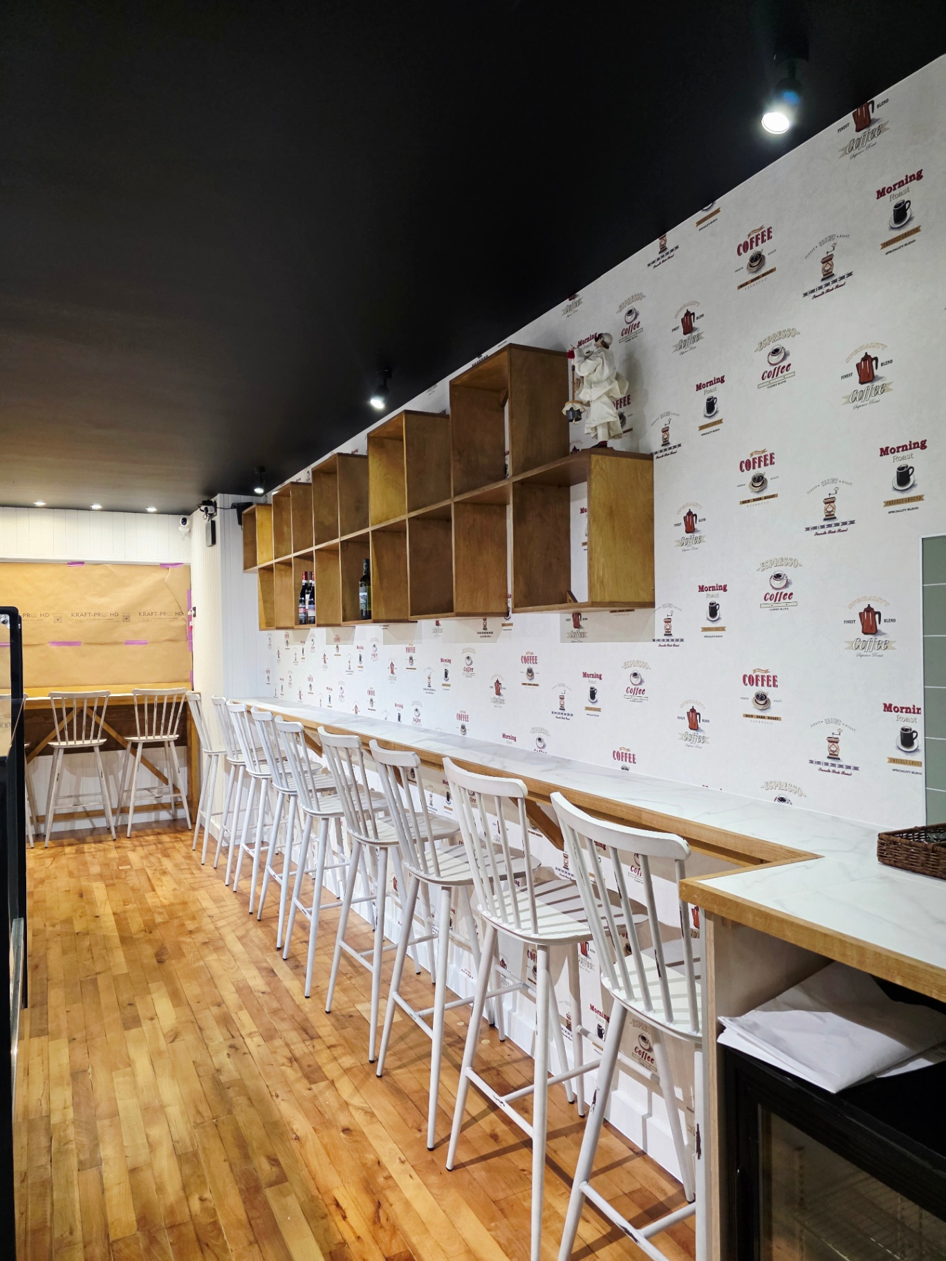 Finished bar seating run with marble-effect counter and white spindle stools