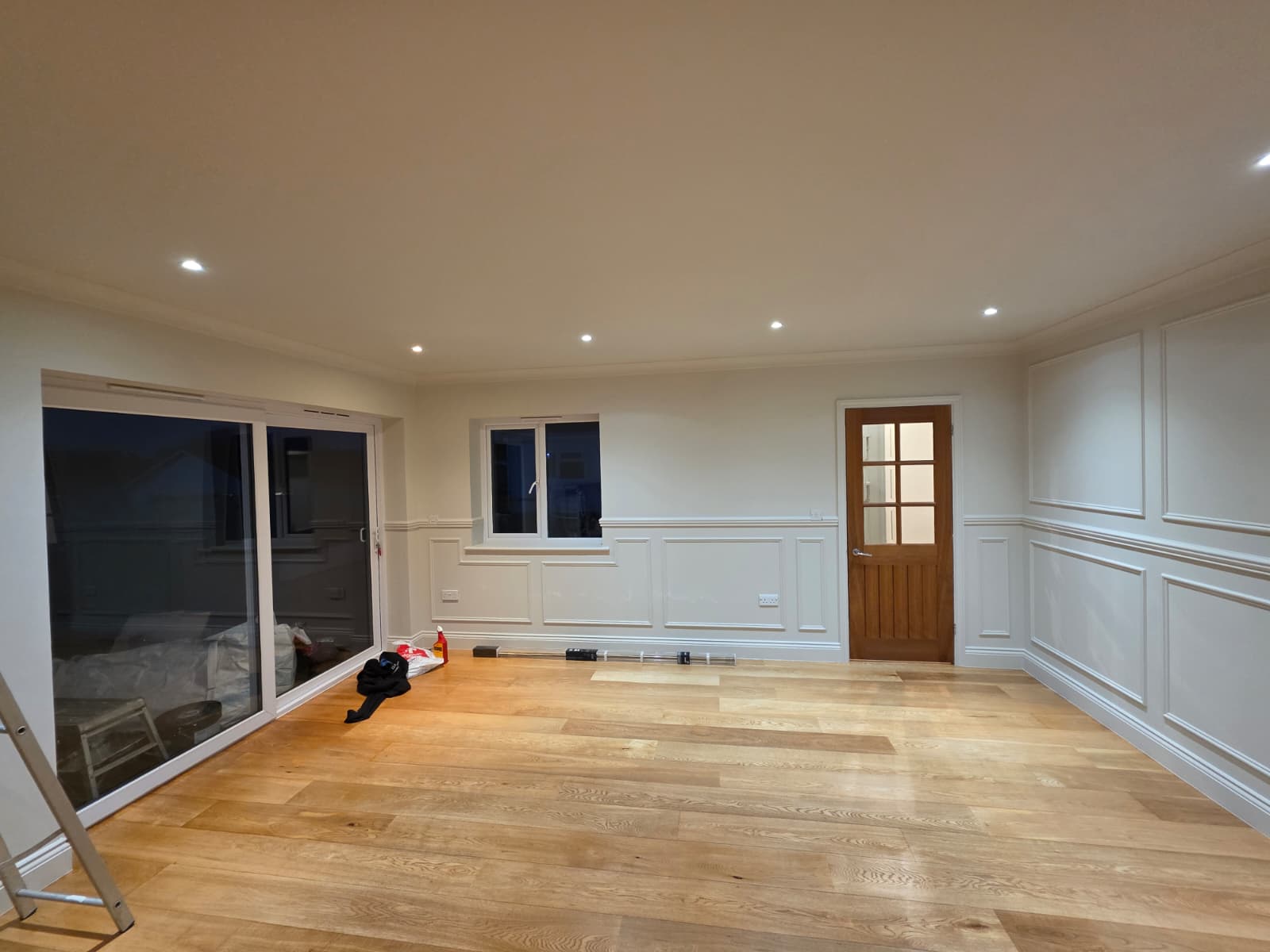 Panelling painted in a soft off-white with warm downlighting